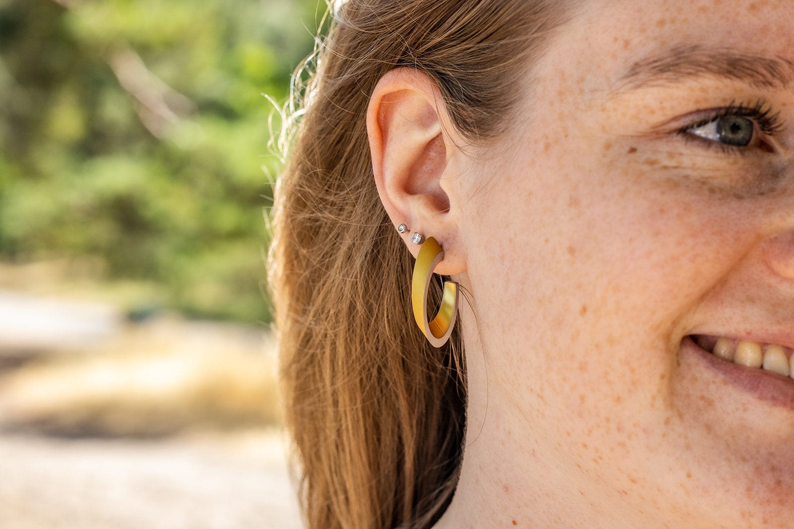 OLIVIA Ohrstecker in Goldfarben getragen | ovale Creolen mit matter Oberfläche | CLIC by Suzanne
